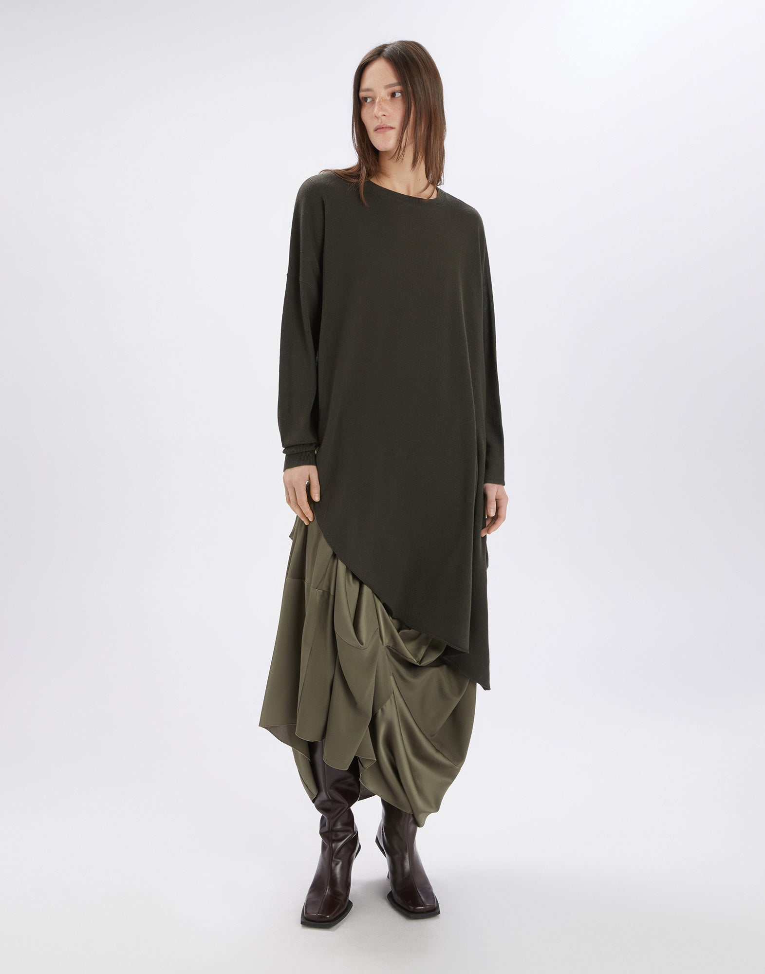 Front view of a person wearing the ON SET tunic; the design is asymmetrically cut, made from a lightweight wool blend with long sleeves and a crew neck.