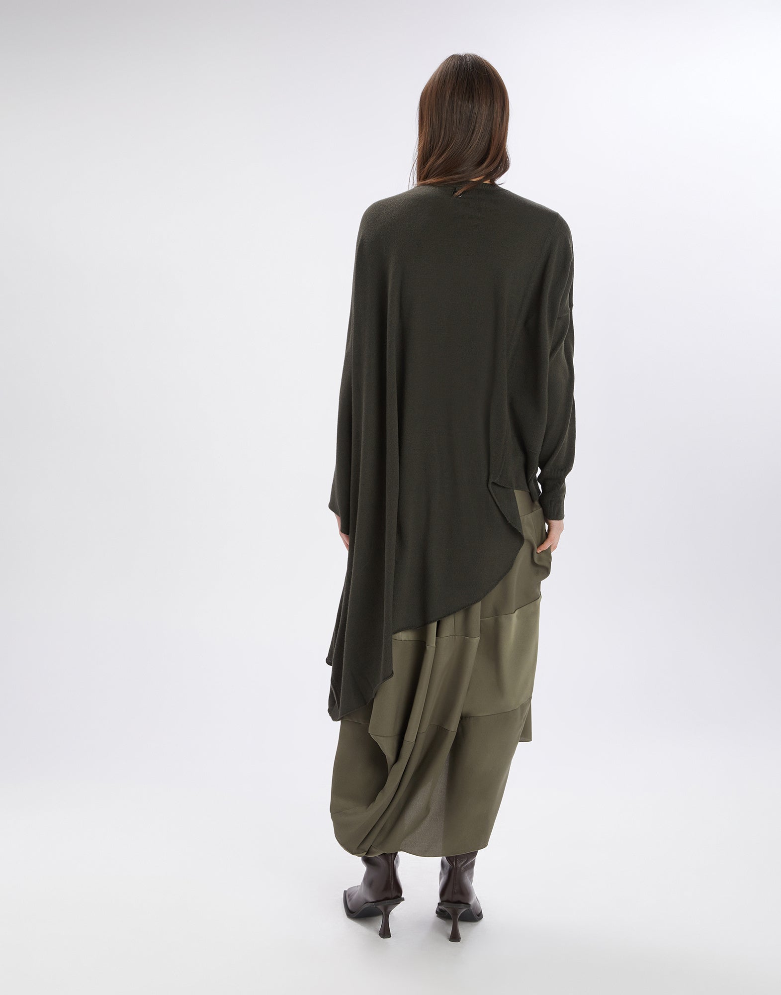 Rear view of a person wearing the ON SET tunic. The garment features an asymmetric cut with flowing, lightweight wool blend fabric and long sleeves.